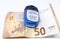 Detailed photo of a small open pocket antibacterial hand gel under a high value Euro banknote reflecting its rising price