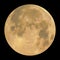 Detailed realistic yellow full moon, isolated on black background.