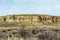 Detailed rock wall lining vast open desert landscape in rural New Mexico