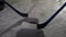 A detailed shot of hockey sticks hitting puck and male legs in skates sliding across ice arena. Professional game of