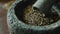 A detailed shot of a mortar and pestle crushing dried herbs into a fine powder releasing a soothing aroma