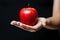 Detailed shot Womans hand grasping an apple, highlighting its vibrant presence