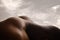 Detailed texture of human skin. Close up shot of young african-american male body like landscape with the sky background
