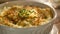 A detailed view of a bowl filled with food sitting on a wooden table