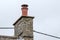 Detailed view of chimney seen on a cottage roof with fitted bird cowl.