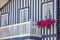 Detailed view of front facade windows and balcony with flowers of typical Costa Nova beach house