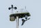 Detailed view of a professional Weather Station atop a mast, showing its various sensors.