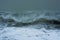 Detailed winter storm wave breaking and splashing on shore