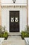 Detailed wooden front door of white brick home