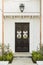 Detailed wooden front door of white brick home