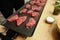 Details with beef steak being cooked by a chef on a stove with butter, salt and rosemary