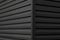 Details of black corrugated iron sheet used as a facade of a warehouse or factory. Texture of a seamless corrugated zinc