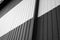 Details of black and white corrugated iron sheet used as a facade of a warehouse or factory. Texture of a seamless