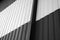 Details of black and white corrugated iron sheet used as a facade of a warehouse or factory. Texture of a seamless