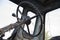 Details of a blue village tractor with dirty wheels, engine, rudder and bucket with an arrow in the summer