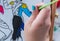 Details of children`s hands painting with watercolor in an artistic learning workshop