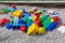 Details of a children's multi-colored plastic construction set on the sand. Pears forgotten by children on the