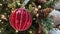 Details of christmas tree with red bauble and pine cone