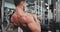 Details closeup to the camera good looking bodybuilding man concentrated working at gym