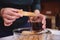 Details: confectioner hands dipping ladyfinger biscuit cookies into a glass of strong sweet espresso coffee. Step-by-step recipe