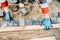 details of construction worker laying granite cobblestone on road pavement