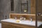 Details of corner with water tap sink with faucet with soap and shampoo dispensers in expensive bathroom in rustic eco style