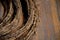 Details of dry vine circle wreaths on distressed wooden surface background. Closeup of grapevine twigs texture. Natural backdrop
