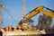 Details of excavator scoop destroying and loading debris into a dump truck. Construction background.
