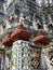 Details of the facade with statues and red pyramids on the Wat Arun Temple, Temple of Dawn, in Bangkok, Thailand
