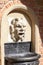 Details of fountain with mascaron in the courtyard of Collegium Maius, Krakow, Poland