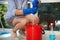 Details: gloved hands of housewife squeezing a floor cleaning cloth into a red bucket during a general cleaning. Chores