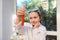 Details: hands of a little chemist observing a test tube with going chemical reaction with fascination and excitement