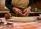 Details: hands of woman chef confectioner, baker holding a heart shaped cookie cutter above rolled out gingerbread dough