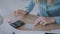 Details. modern office, female hands close-up, a girl counts on a calculator and makes notes in a notebook 4K