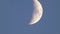 Details on moon up in the sky on winter afternoon on clear blue sky