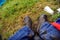 Details with the muddy boots and jeans of a man sitting in a tent at a music festival during a rainy summer day.