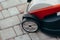 Details near the new electric lawn mower on the tile near the garden. toned photo