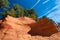 Details of orange rock formation and trees under blue sky on Le