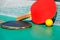 Details of pingpong table with playing equipment and yellow ball.