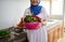 Details on a pink bowl with washed fresh organic vegetables in the hands of a housewife in hijab and authentic dress