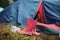 Details with pink rubber boots outside a tent in a camping area of a music festival during a rainy summer day