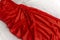 Details of satin red elegant dress. Women`s dress made of silk on white background. Evening outfit. Wave texture