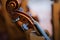 Details with the scroll, peg box, tuning pegs, strings, neck and fingerboard of a violin before a symphonic classical concert