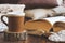 Details of still life in the home interior living room. Beautiful tea Cup, cut wood, books and pillows, candle on wooden backgroun