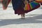 Details of a white shoe and colourful fabrics of a dancing monk in a temple in India