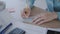 Details. working large desk in the office. woman takes notes on a paper note. 4K