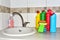 Detergent bottles and sponge near the kitchen sink at home. Detergents and laundry concept. Kitchen sponges and household