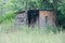 DETERIORATING WOODEN SHACK BETWEEN TREES IN NATURE IN A SOUTH AFRICAN LANDSCAPE