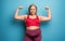 Determinated girl wants to remove fat and does gym at home. satisfied expression. cyan background