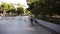 Determinated young man running on inline roller skates at ramp in public skate park, makes a jump and hangs in a time